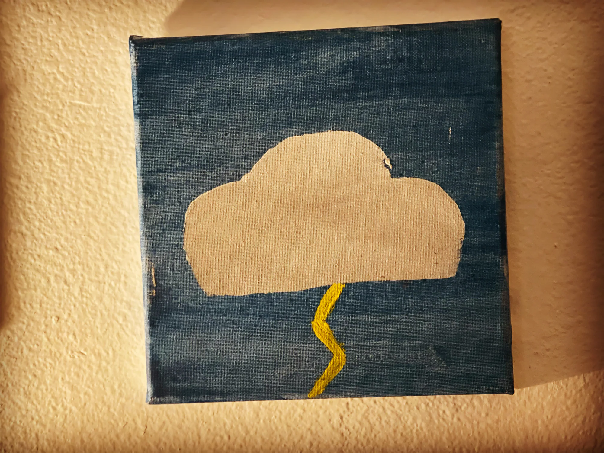 Gray storm cloud and yellow lightning against a dark sky