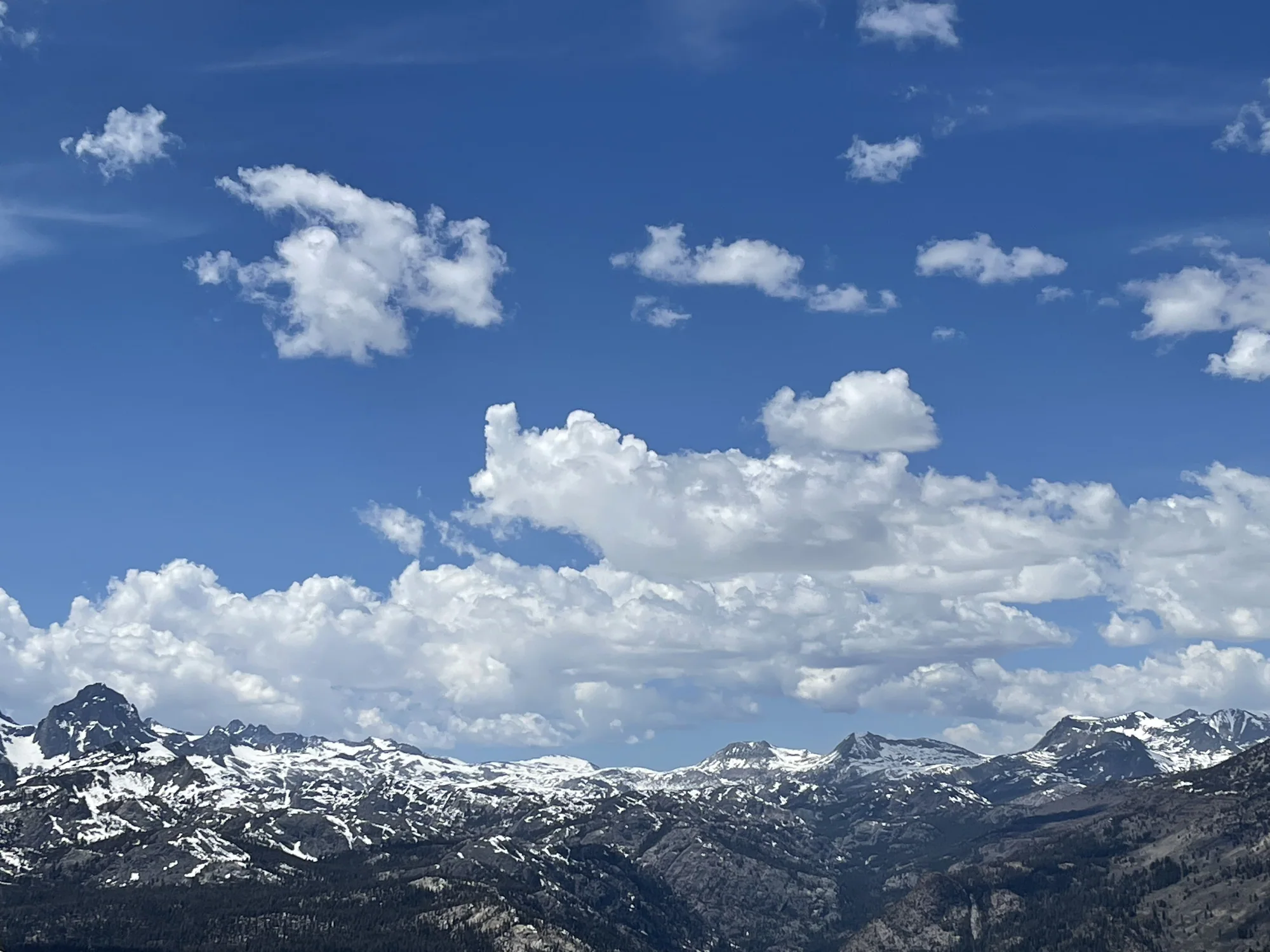 Mountain range beneath towering cumulus clouds